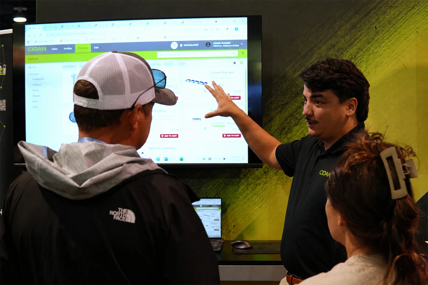 A nuIT application expert explains the platform to a customer at a large screen
